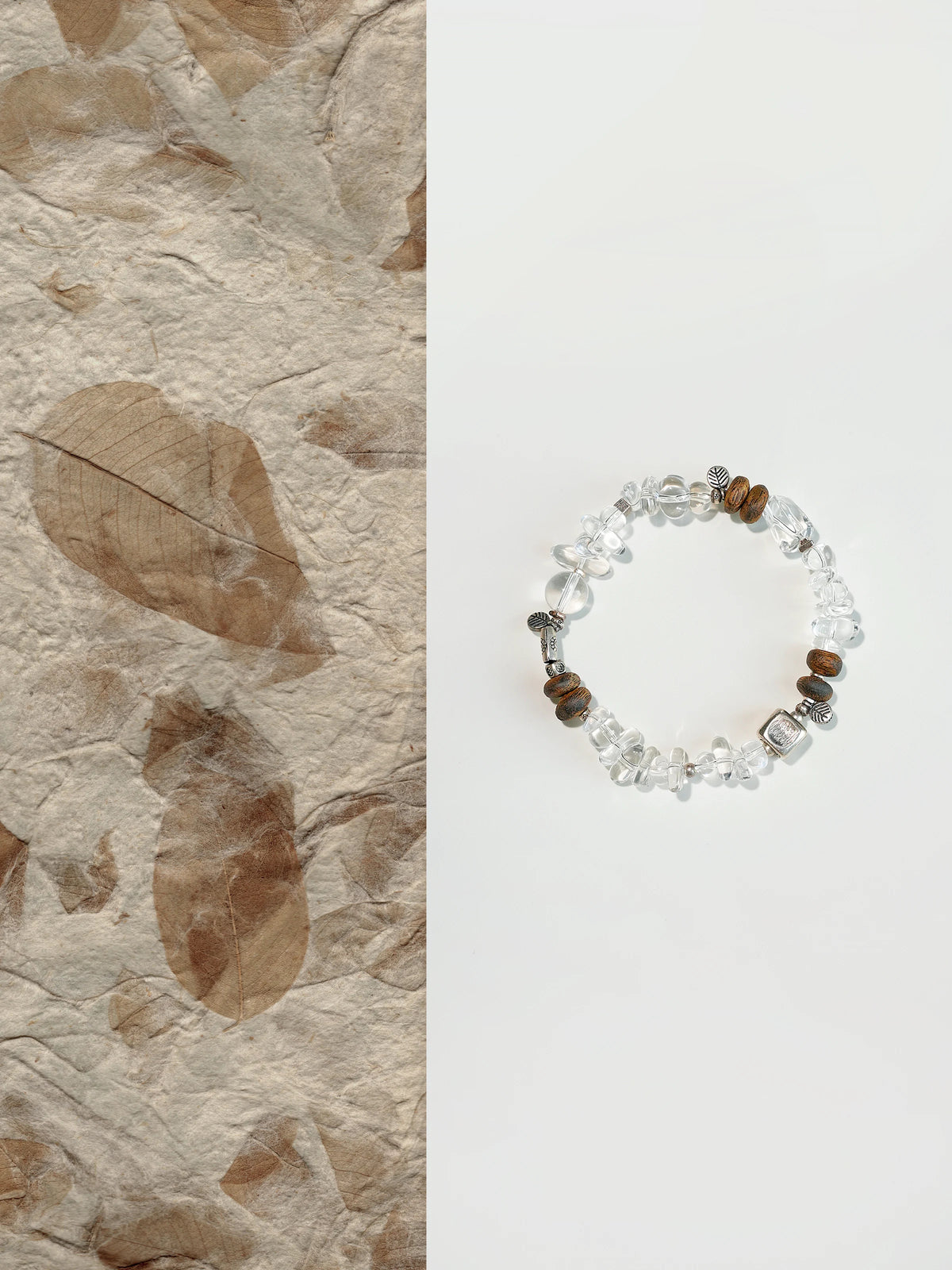 Pine clear quartz and agarwood bracelet with silver cube on leaf-paper background