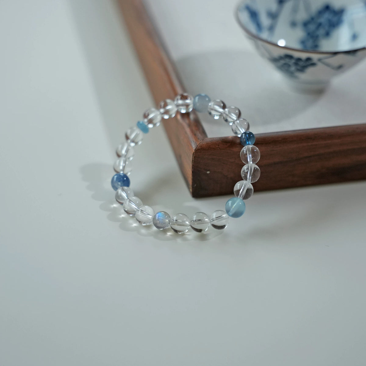 Tide clear quartz and aquamarine bracelet beside a blue and white tea cup