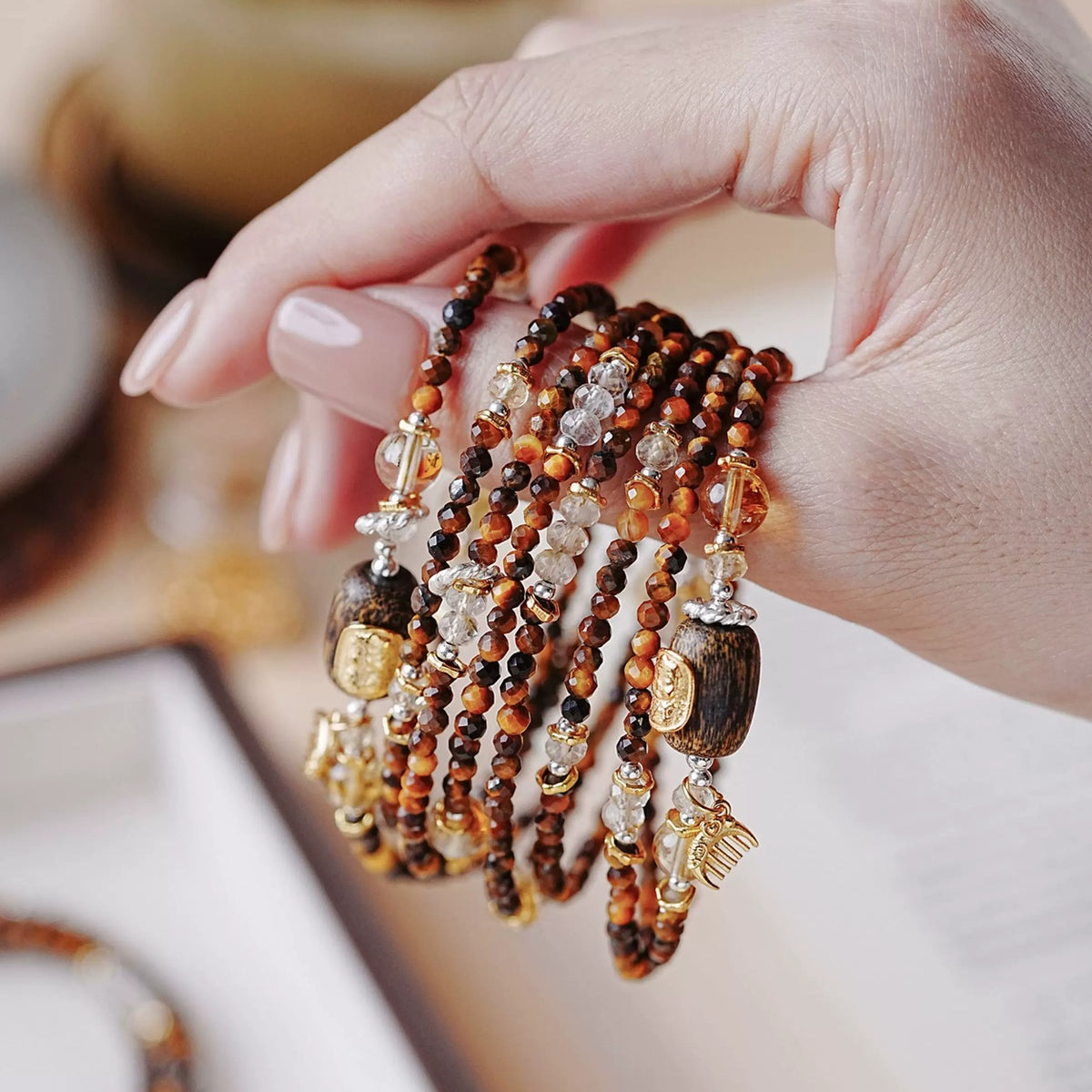 Handheld detail of tiger's eye, yellow crystal and agarwood beads