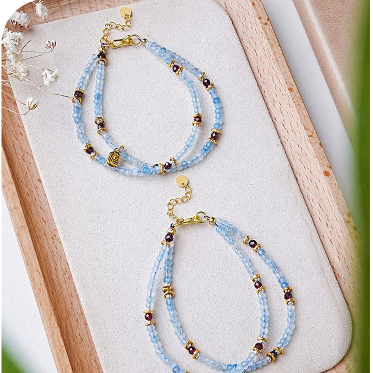 Aquamarine double-strand bracelets styled on a wooden tray