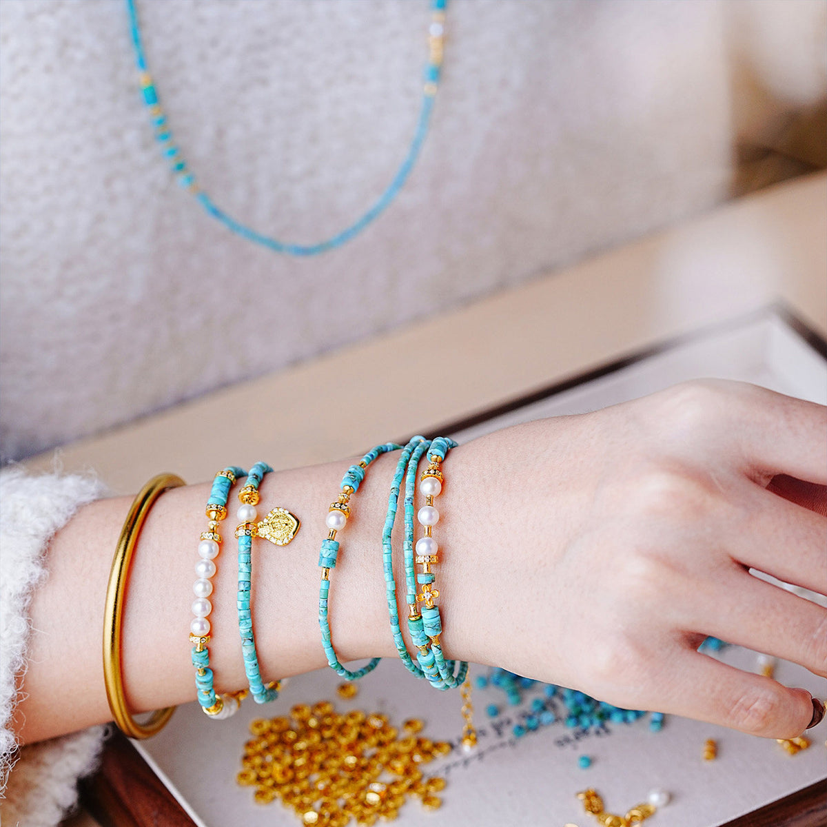Turquoise and pearl multi-wrap bracelet worn on wrist