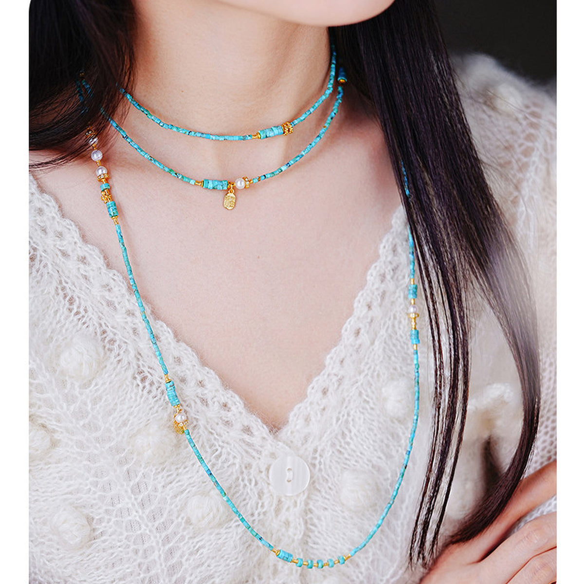 Long turquoise necklace worn on model