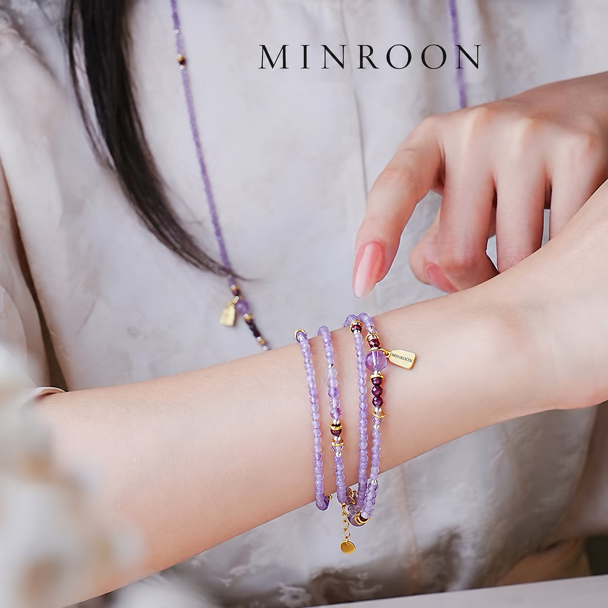 Model wearing the amethyst strand as a layered bracelet