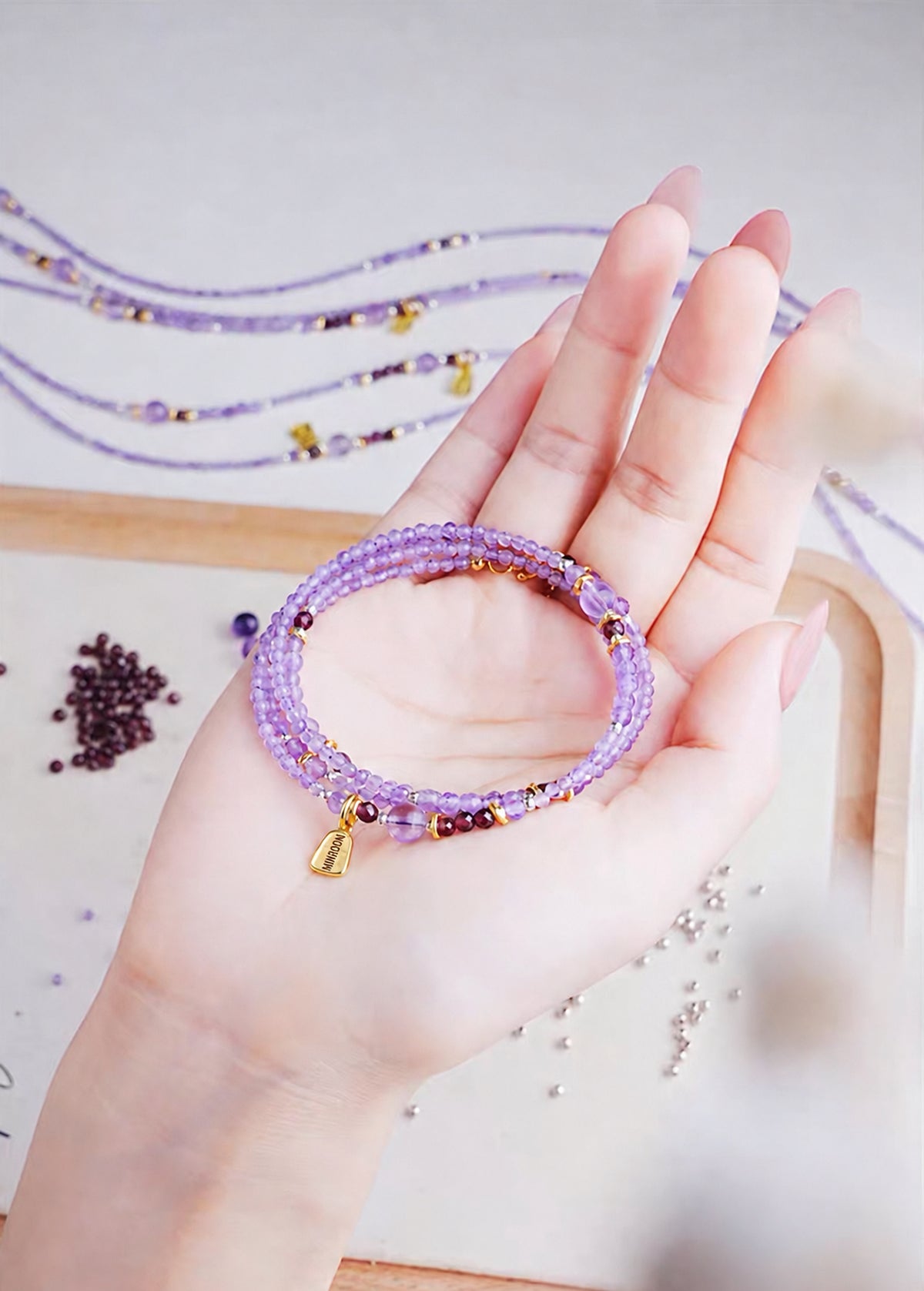 Coiled amethyst bracelet held in a hand