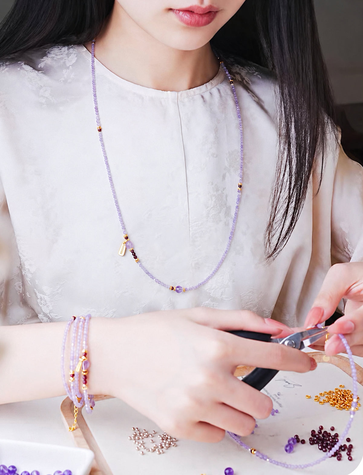 Model wearing the long amethyst strand as a necklace and bracelet